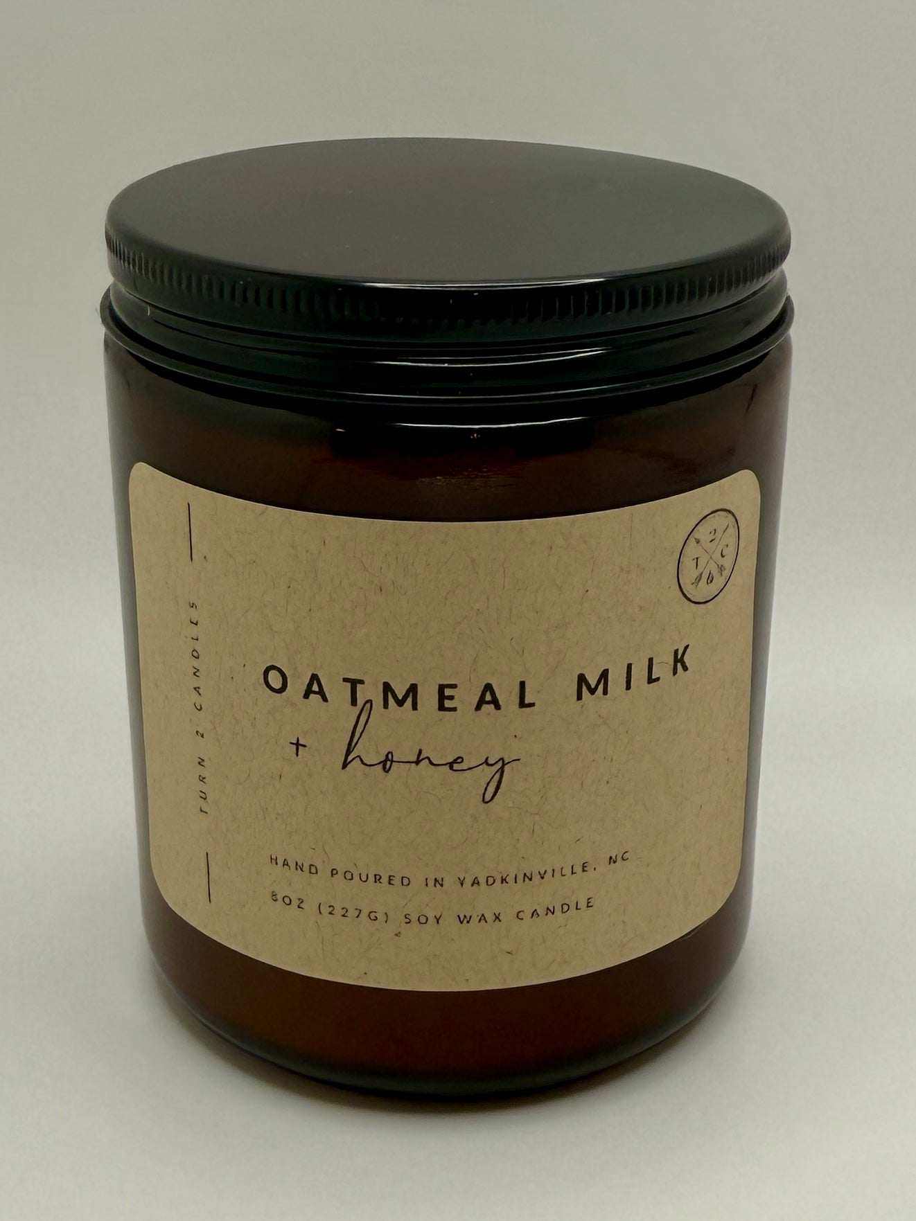 8oz amber jar candle with oatmeal milk and honey scent in amber glass jar with black lid