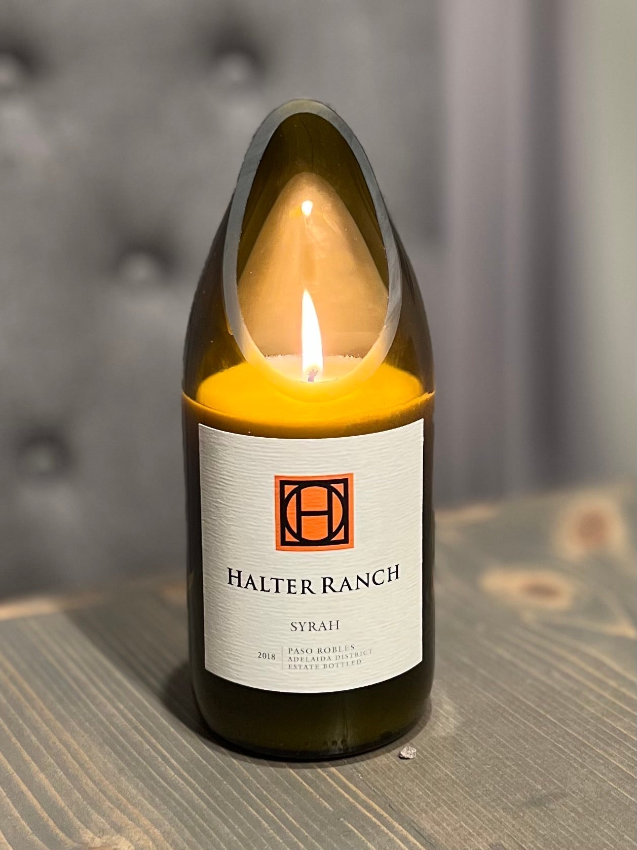 Upcycled wine bottle candle made from a customer-supplied bottle, hand-poured with soy wax and lit to show the finished custom candle