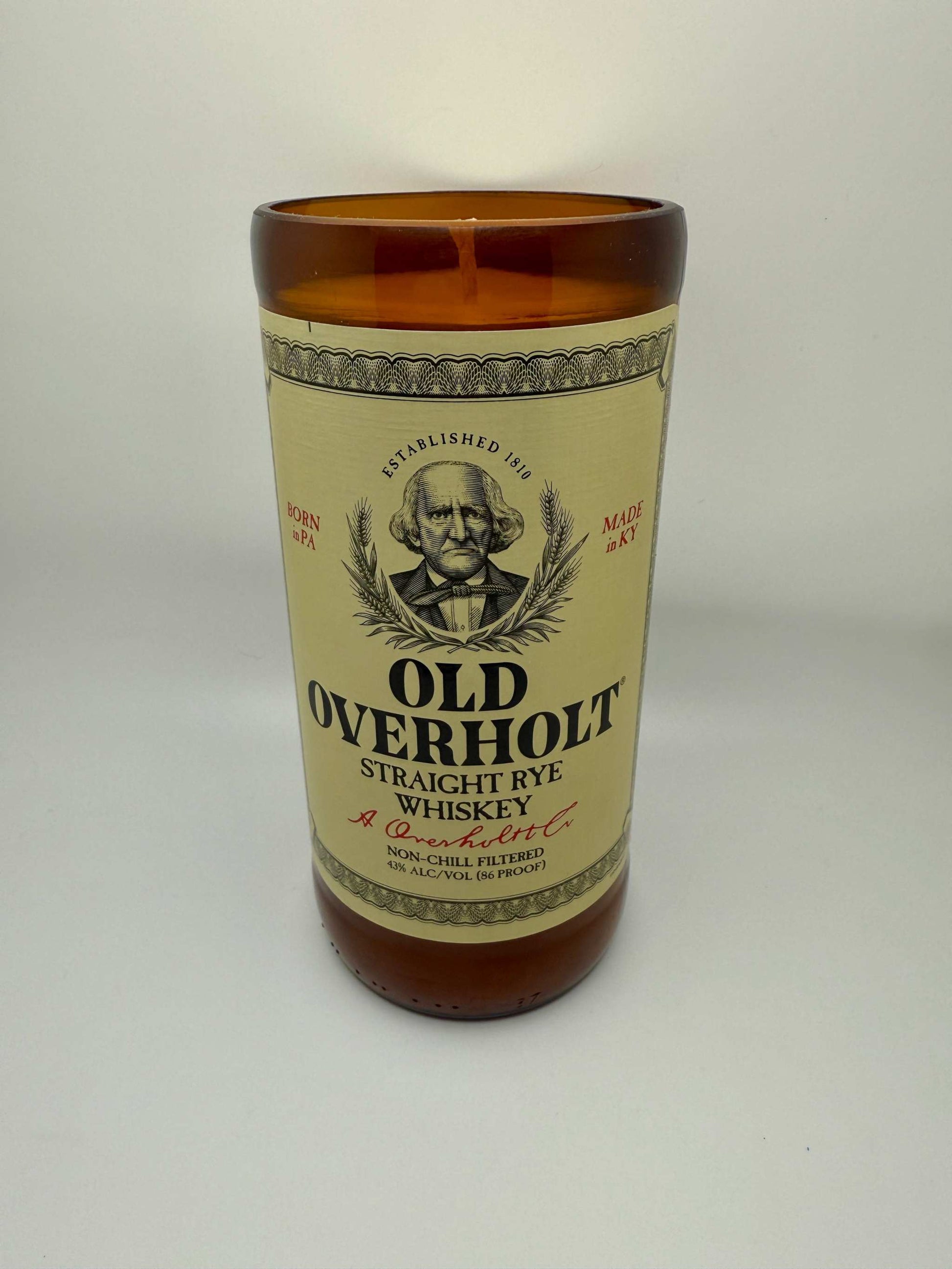 Upcycled whiskey bottle candle with Old Fashioned fragrance featuring bourbonwood, orange, and black cherry notes