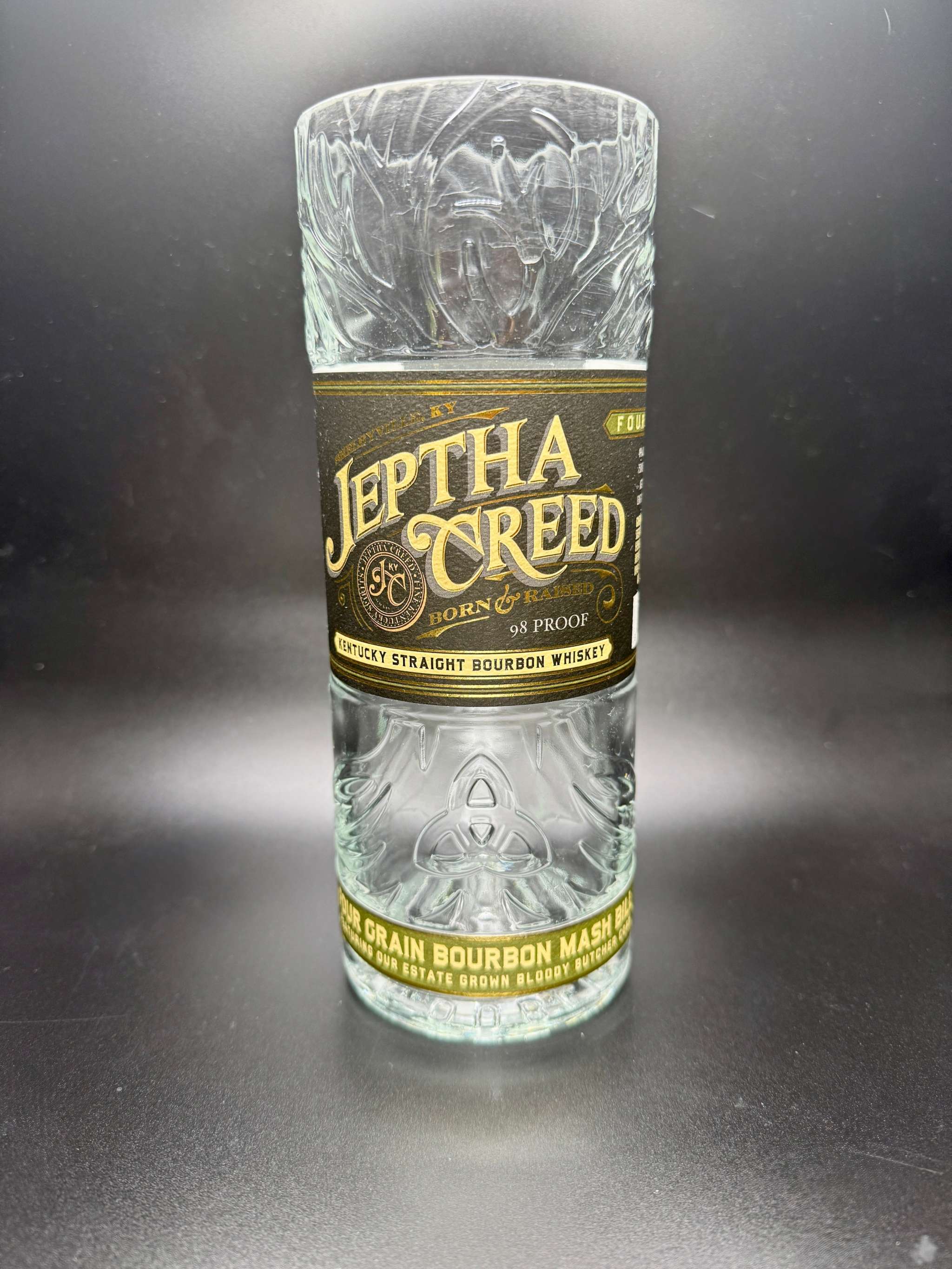 whiskey bottle candle in an upcycled Jeptha Creed bourbon whiskey bottle with custom soy wax filling