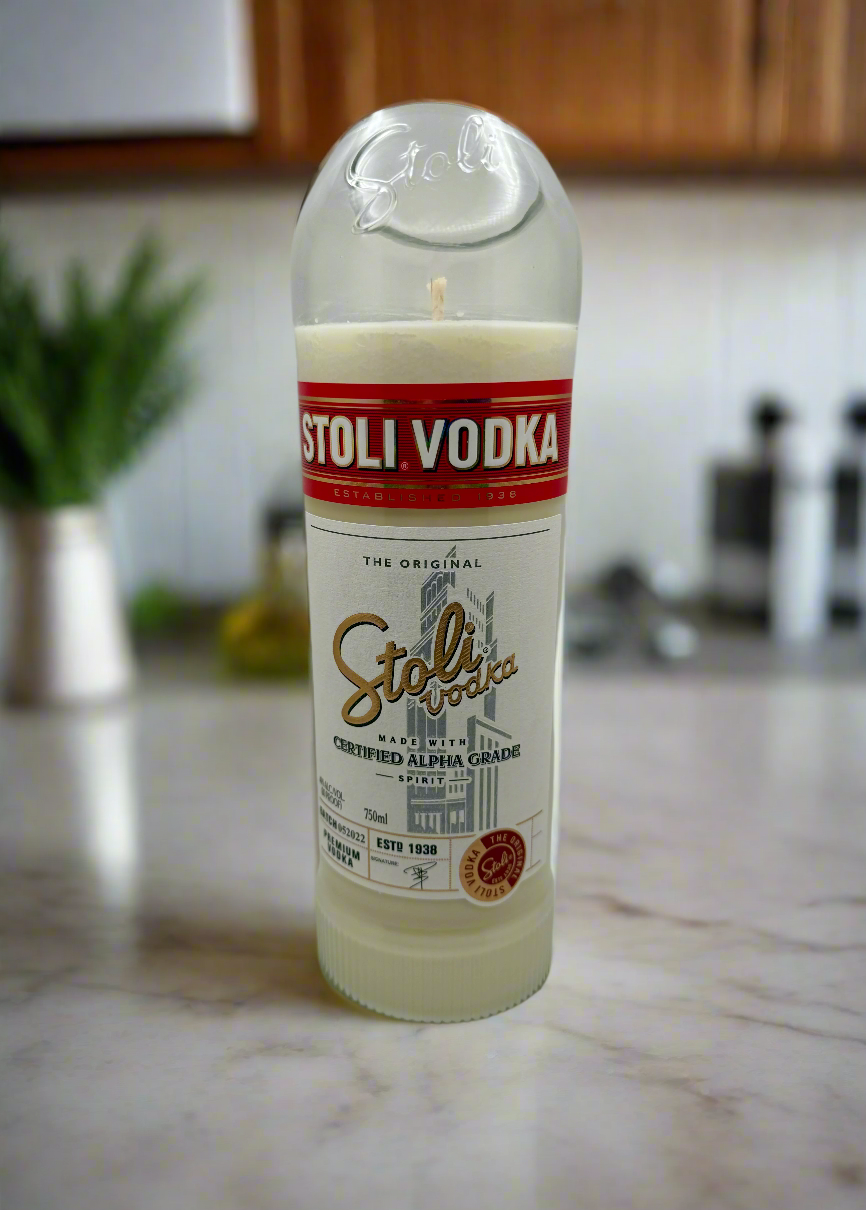 Upcycled vodka bottle candle with mango and coconut milk fragrance on marble countertop