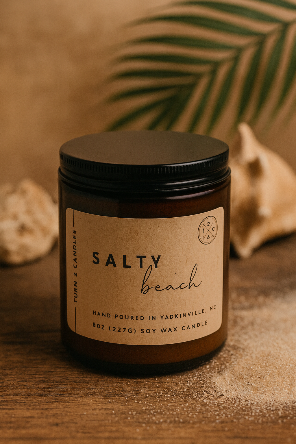 Candle jar labeled 'Salty Beach' on a wooden surface with natural elements.