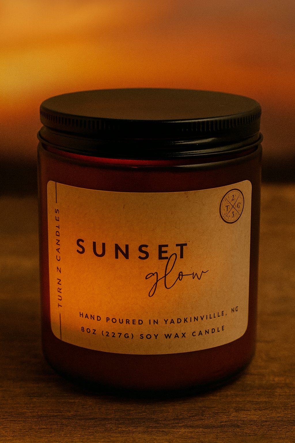 Candle jar labeled 'Sunset Glow' with a warm glow on a matching background